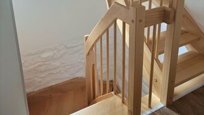 A wooden staircase with a handrail, leading to a landing with a small window. - Ferienparadies in der Vulkaneifel (Gerolstein)