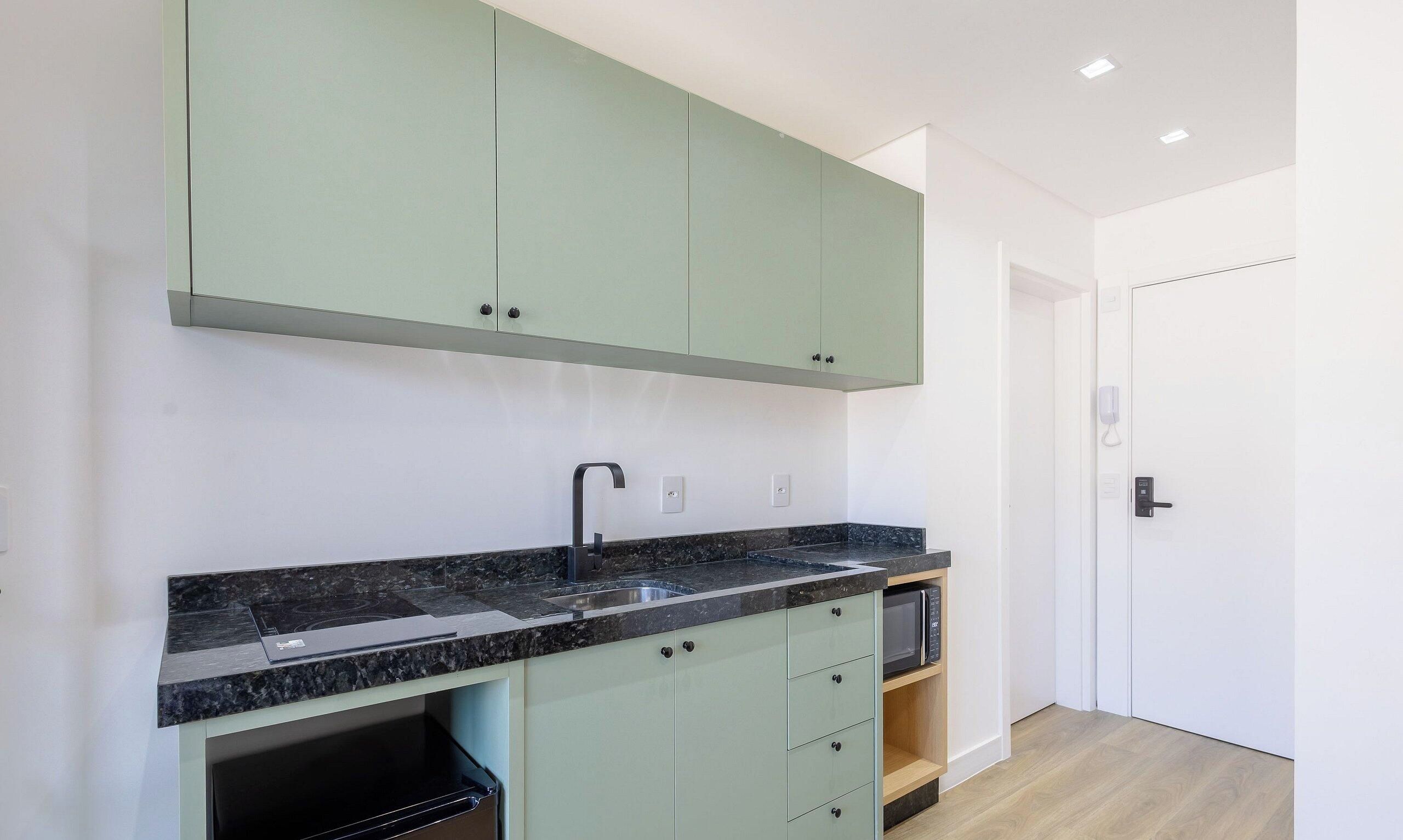 A modern kitchen with a built-in stove, a sink, and a microwave.