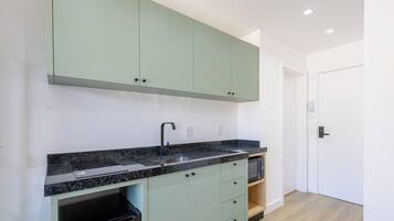 A modern kitchen with a built-in stove, a sink, and a microwave.