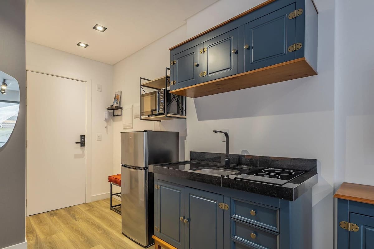 A compact kitchen with a built-in oven, a microwave, and a sink.