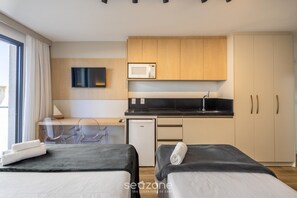 A modern hotel room with two beds, a kitchenette, a flat-screen TV, and a view of the outdoors. - New Studios - Pool With sea View - Penha Spot PSO (Penha)