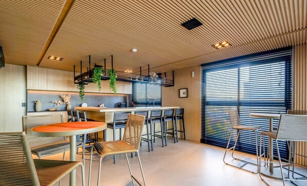 A modern interior with a kitchen, dining area, and large windows. - New Studios - Pool With sea View - Penha Spot PSO (Penha)