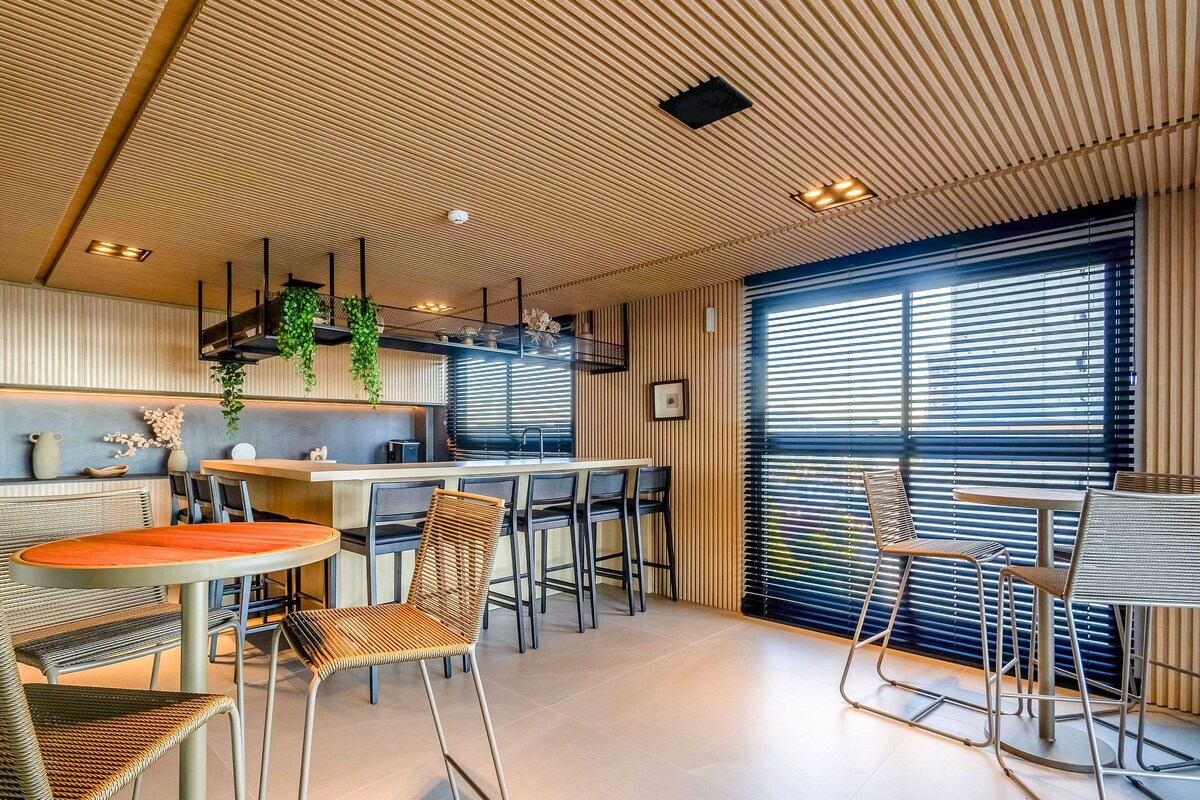 A modern interior with a kitchen, dining area, and large windows.