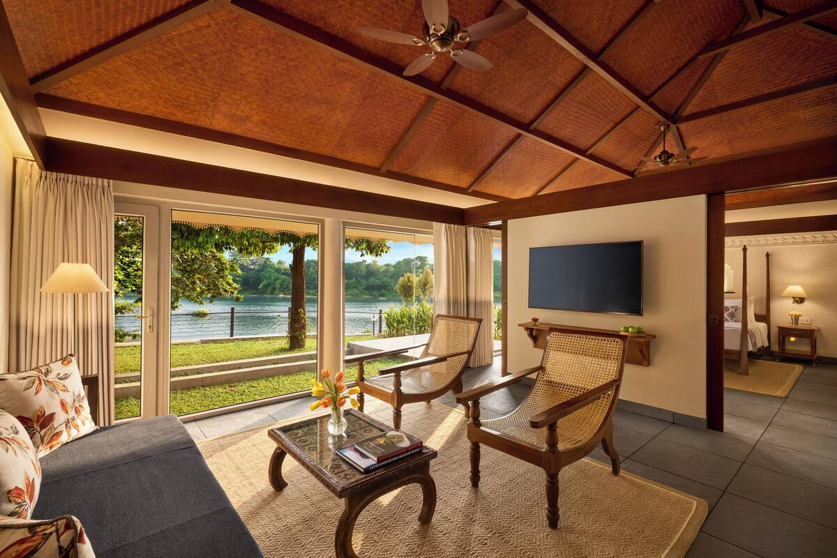 Ein geräumiges Wohnzimmer mit großem Fenster und Seeblick, Deckenventilator und flachbildschirmfernseher an der Wand.