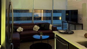 Ein modernes Wohnzimmer mit einer Couch, einem Couchtisch und einem Fernseher.