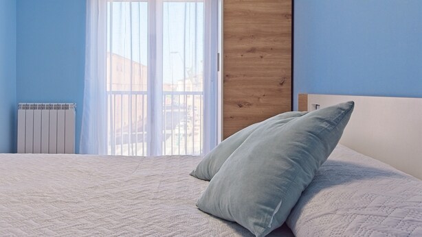 A bedroom with a bed, a window with a view, and a radiator. - Apartment 'Osiris' with Wi-Fi (San Andrés del Rabanedo)