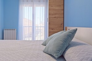 Une chambre à coucher avec un lit, une fenêtre donnant sur un beau paysage et un radiateur.