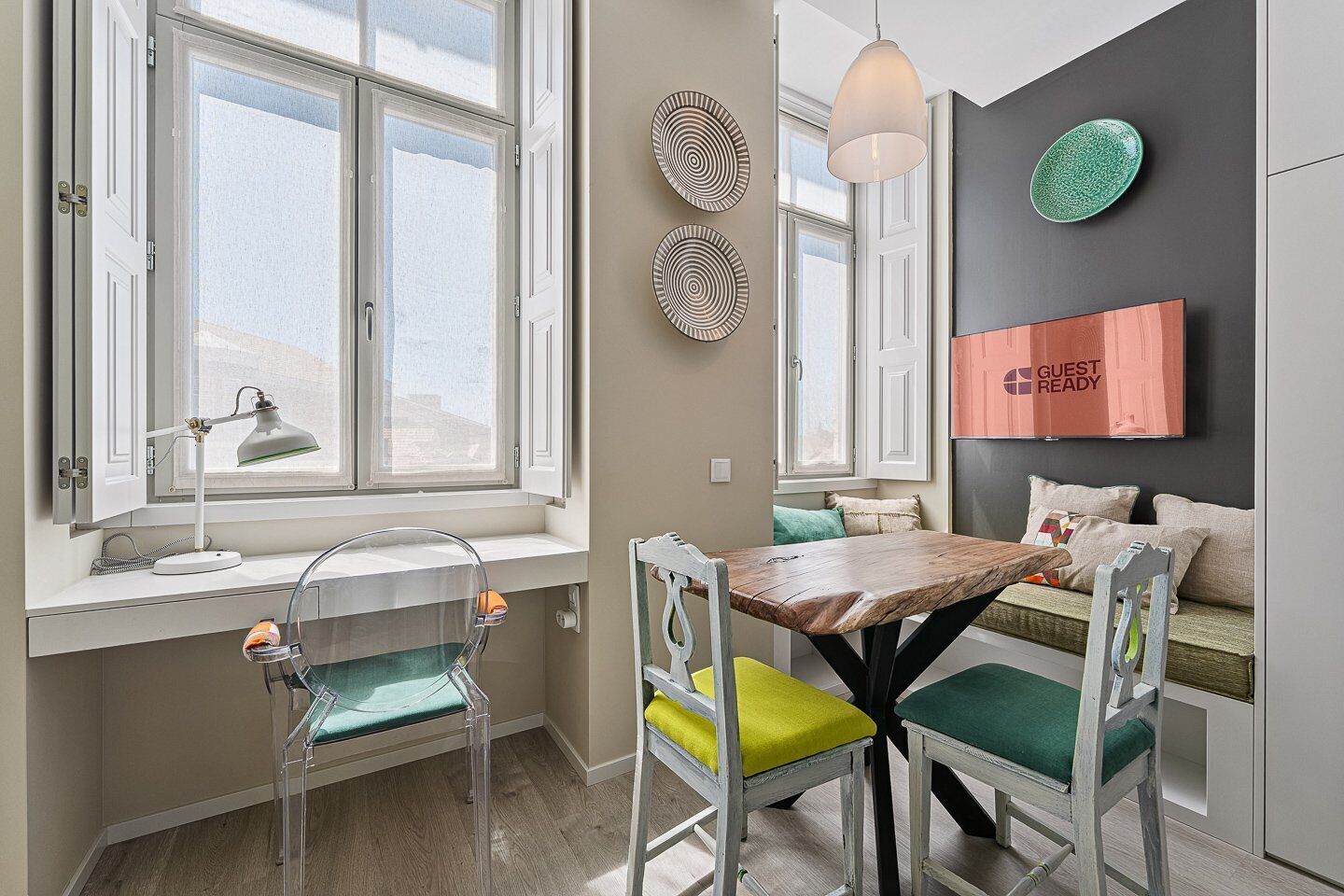 A modern kitchen with a dining table, chairs, and a window with a view.