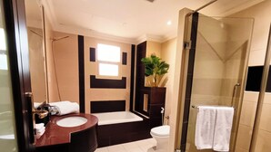 A modern bathroom with a glass-enclosed shower, a bathtub, a toilet, and a vanity with a sink.