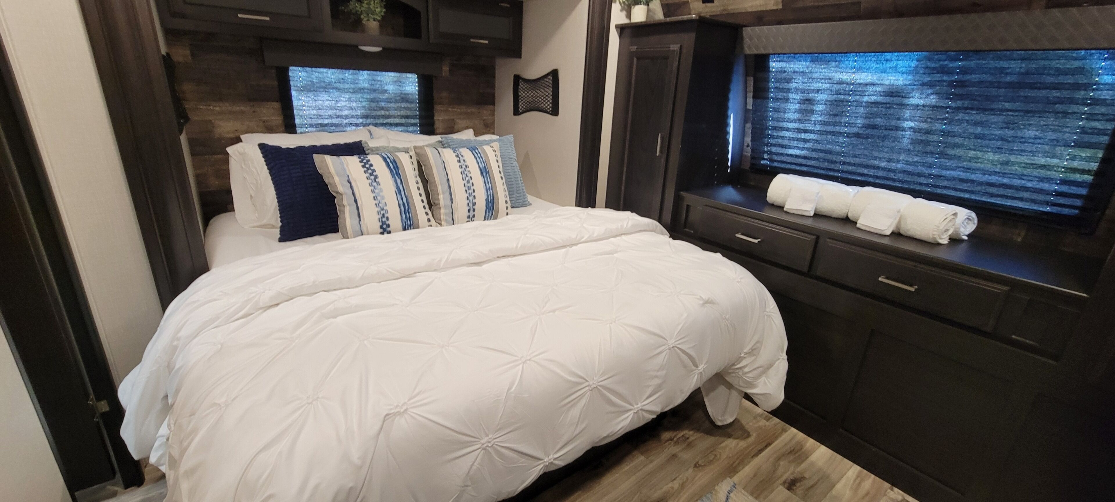Une chambre à coucher avec un lit, une commode et une fenêtre avec des stores.