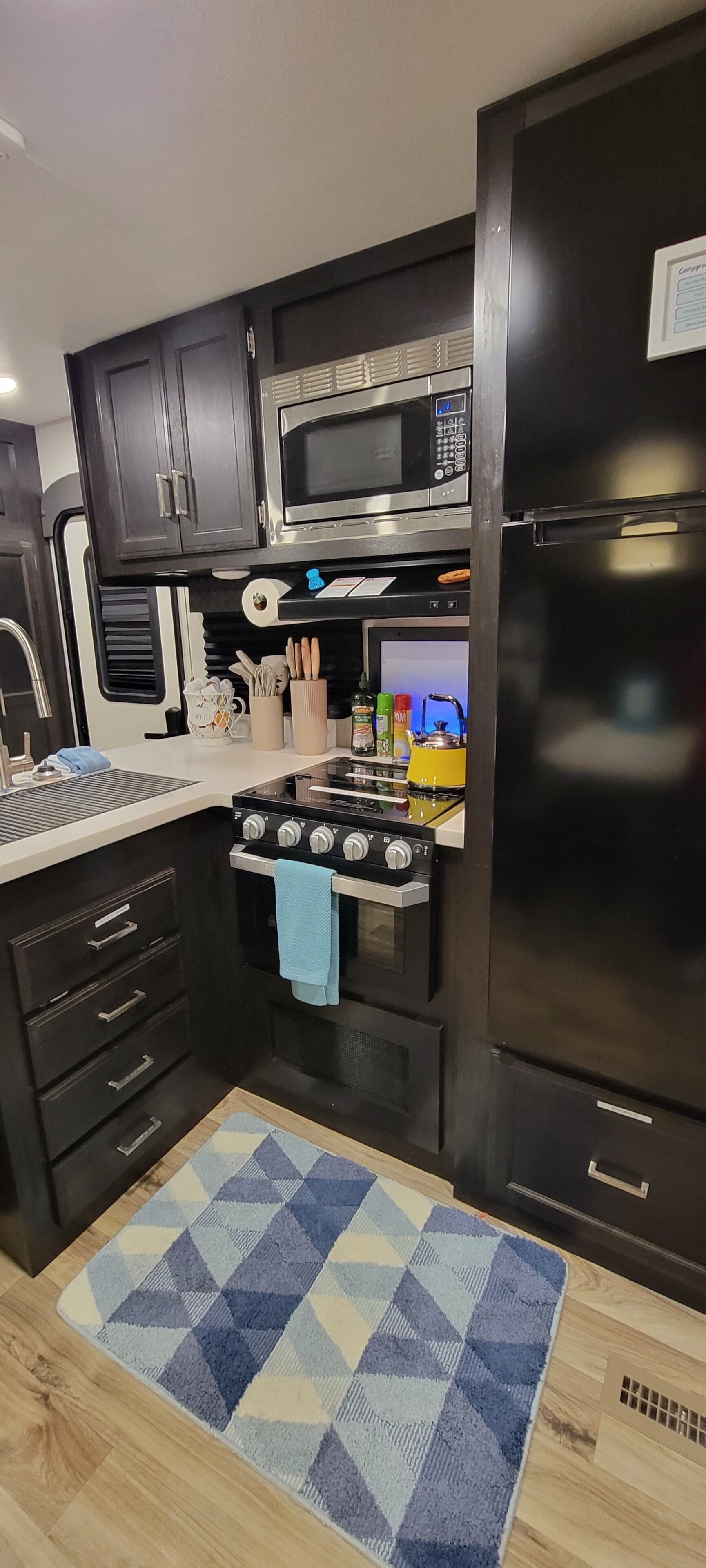 A compact kitchen with a microwave, stove, and refrigerator.