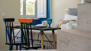 A dining area with a table, chairs, and a window with curtains.