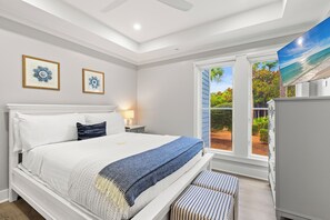 A bedroom with a large bed, a window with a view of the outdoors, and a ceiling fan. - Community Pool, Luxury! Gulf Front, Watersound (Santa Rosa Beach)
