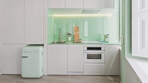 Une cuisine compacte avec un seul évier, un petit four et un réfrigérateur au style rétro.