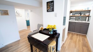 Een moderne keuken met houten kastjes, een ingebouwde oven en een aanrecht met diverse keukenbenodigdheden.