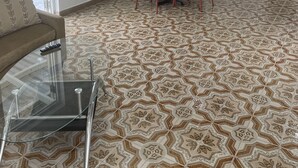 Een knus woongedeelte met een eethoek, kitchenette en een bank met glazen tafel.