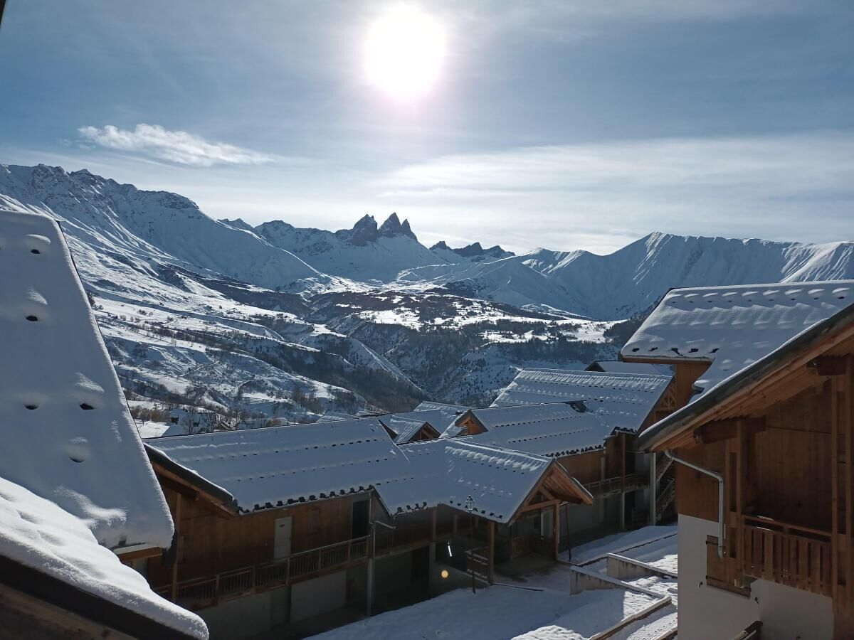 Un pueblo cubierto de nieve con edificios de madera y una vista despejada de los picos circundantes.