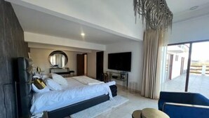 Un dormitorio moderno con cama, televisión, escritorio y silla.