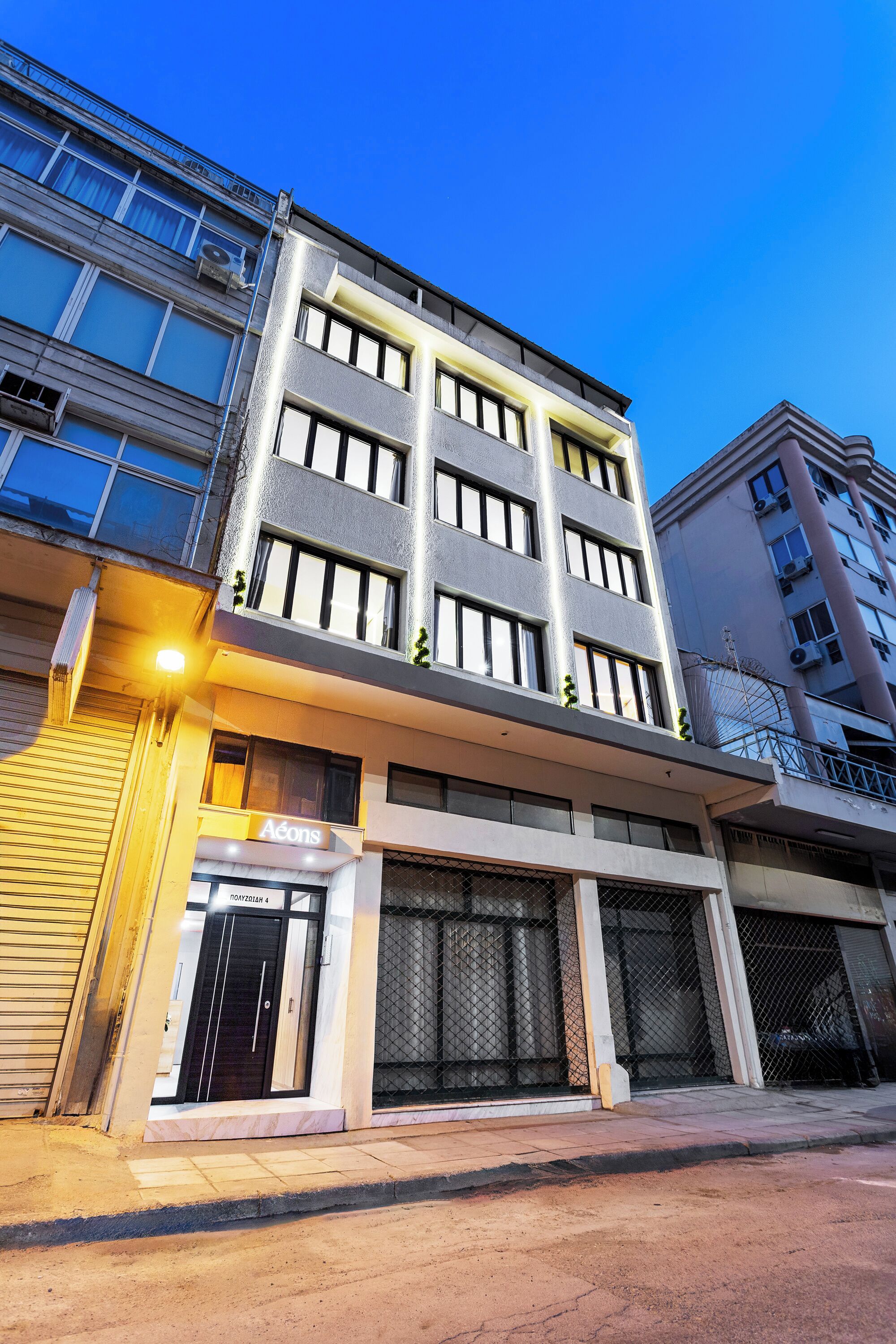 A multi-story building with a modern architectural design, featuring a prominent entrance with a glass door and a sign above it.