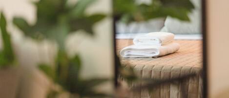 Le reflet d’un lit avec des serviettes blanches soigneusement pliées.