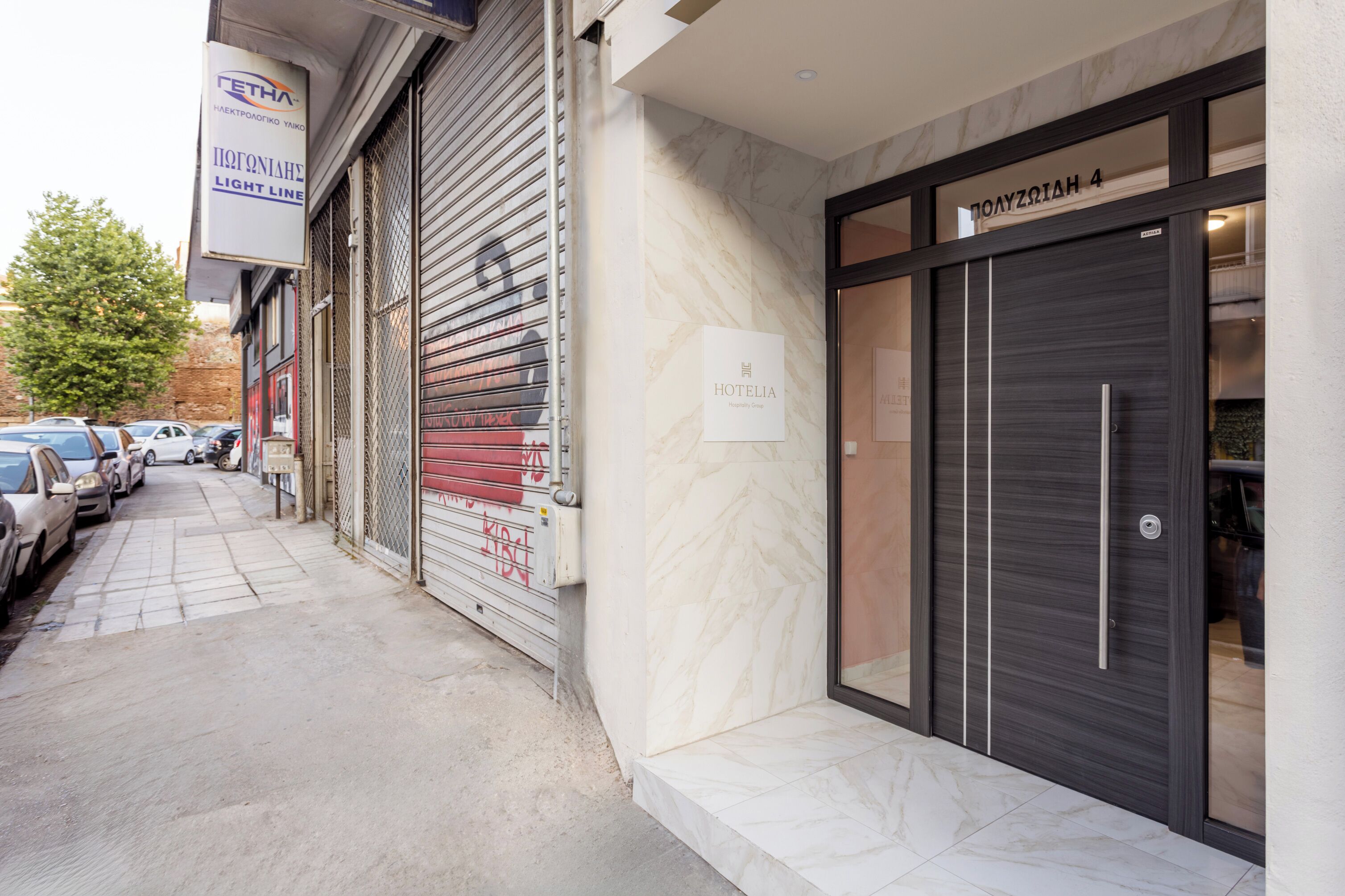 A hotel with a closed shutter, a sign indicating 'HOTELIA', and a '4' above the entrance.