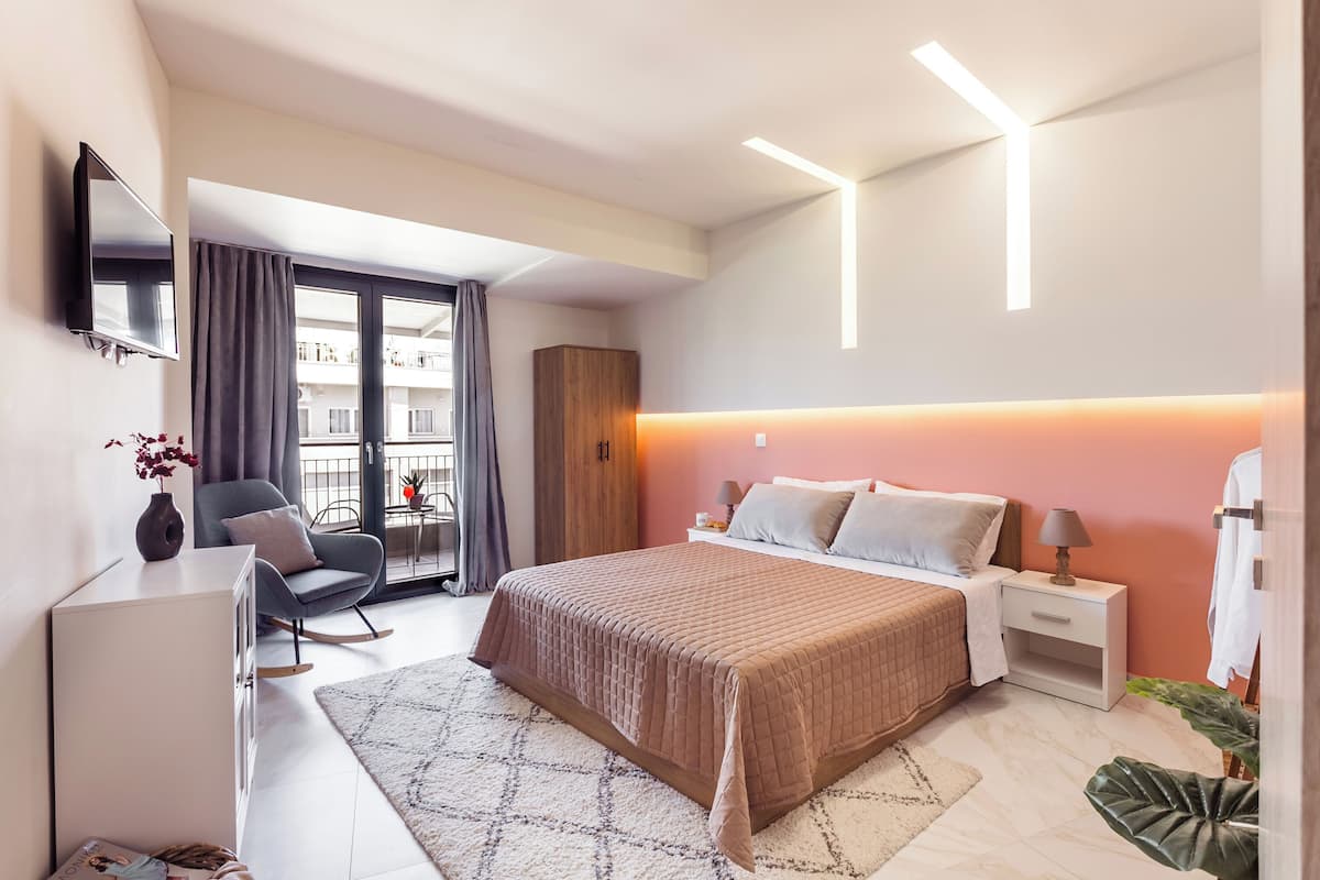 Une chambre d’hôtel moderne dotée d’un grand lit, d’un bureau, d’une chaise, d’une télévision et offrant une vue sur le balcon.