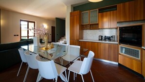 Una cocina moderna con armarios de madera, una mesa de comedor de vidrio y sillas blancas.