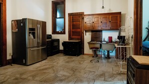 Una cocina con un refrigerador de acero inoxidable, armarios de madera, un lavamanos y una cafetera.