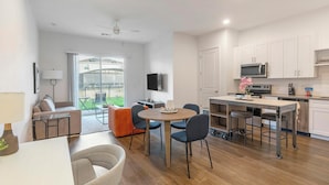 Un appartement moderne comprenant un coin repas, une cuisine et un balcon avec vue.