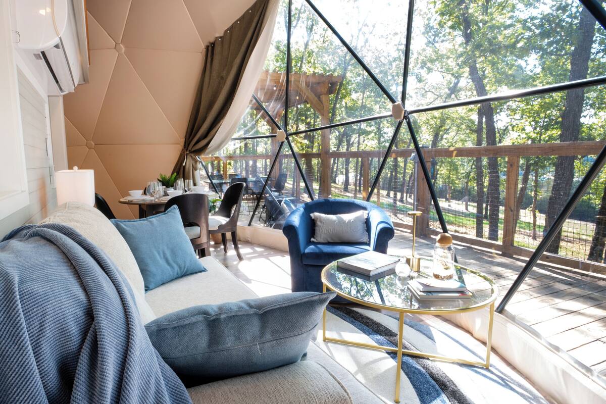 A modern outdoor seating area with a sofa, chairs, and a glass table.