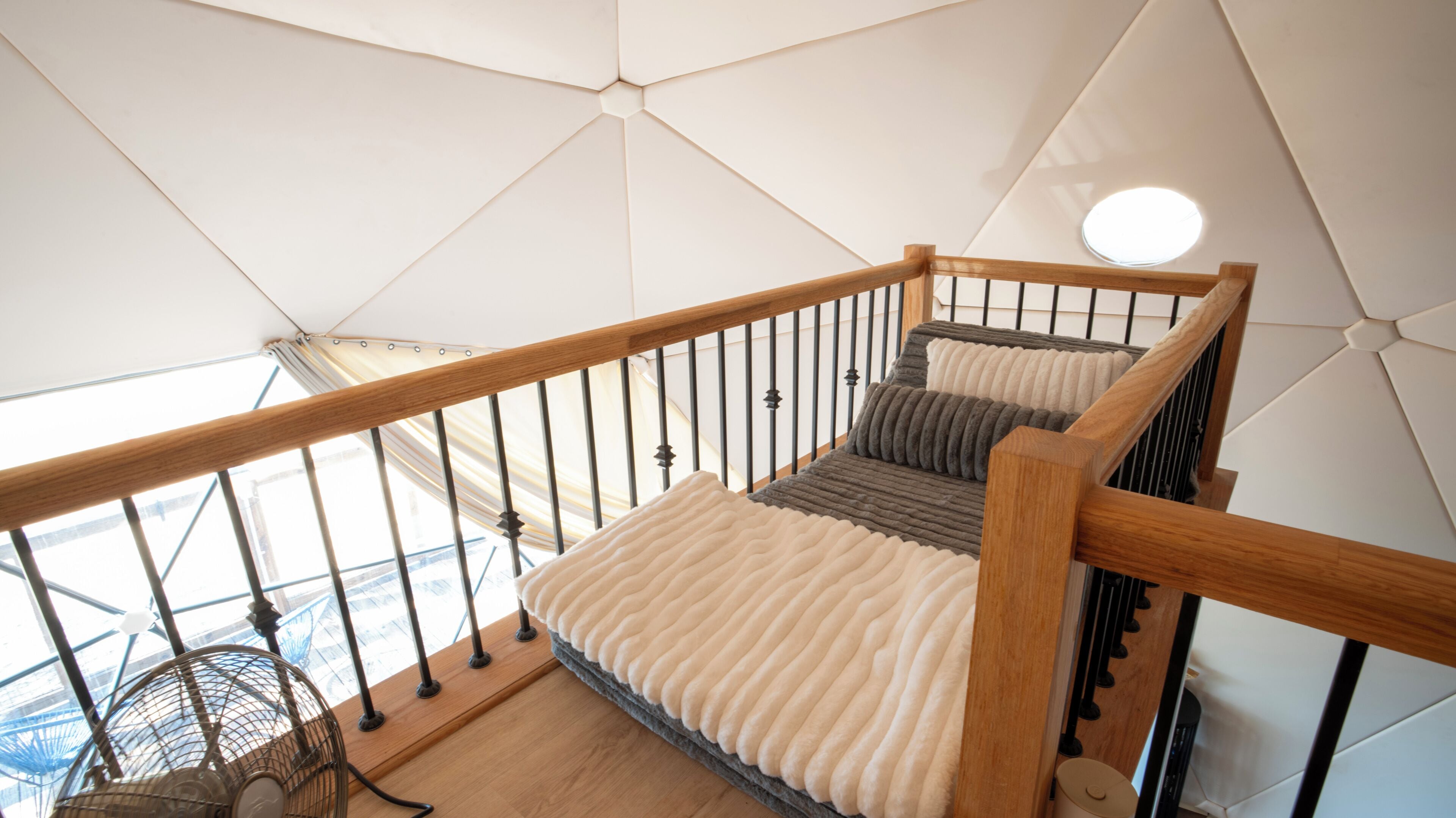 Una escalera con barandillas de madera y un descansillo acolchado.