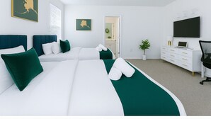 A hotel room with two beds, a desk, a TV, and a potted plant. - Magical Dreams (Kissimmee)