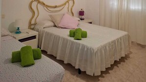 A bedroom with a bed, a nightstand, a lamp, and a ceiling fan.