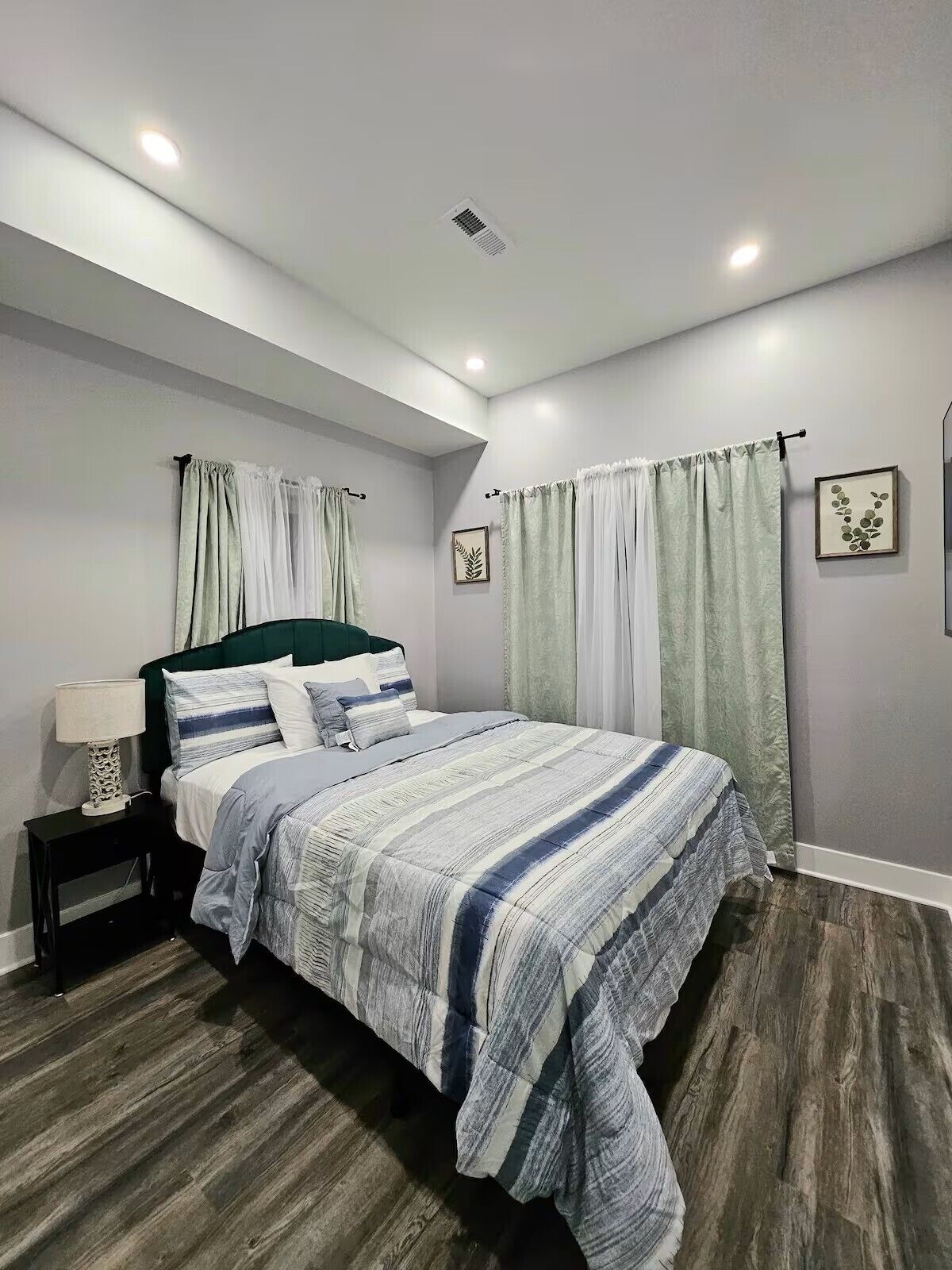 Une chambre à coucher moderne avec un lit, une table de chevet et des œuvres d’art murales.