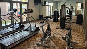 A gym with treadmills, elliptical machines, and weight equipment.
