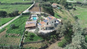 Une maison à deux étages avec une piscine, des panneaux solaires et un jardin.