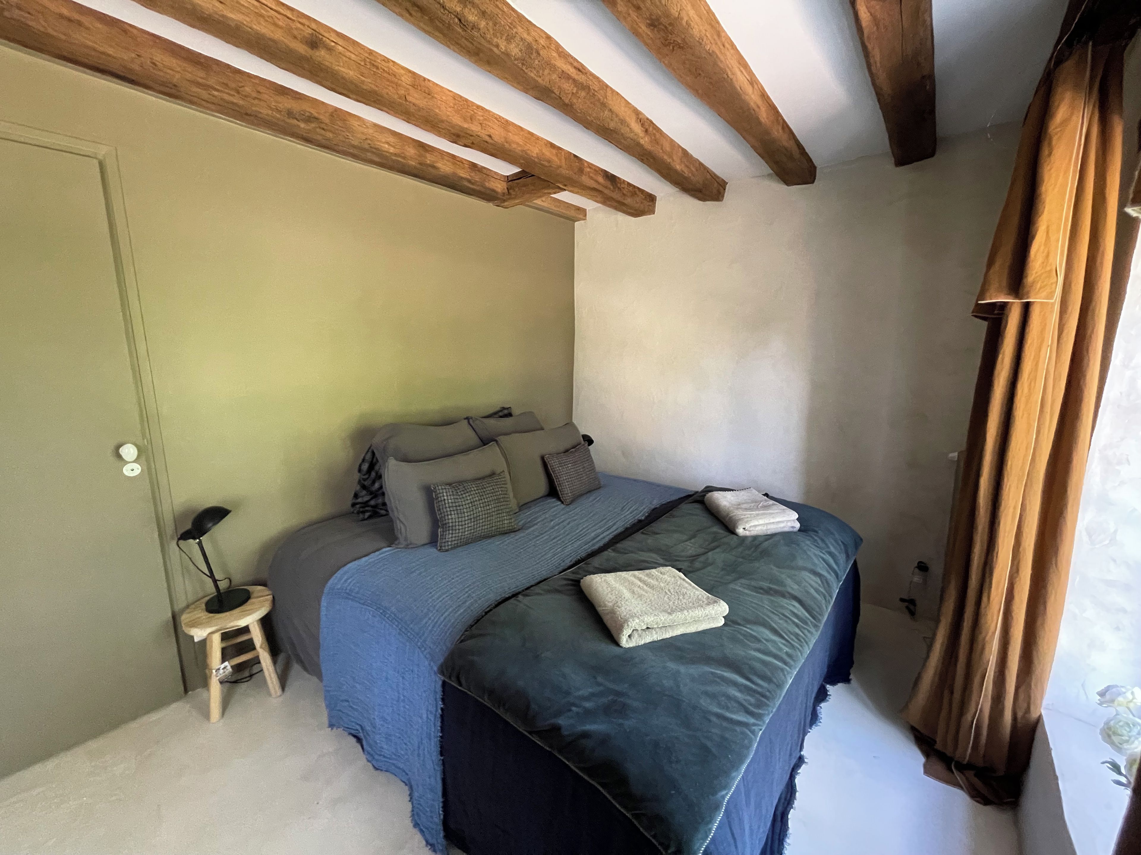 Une chambre à coucher avec un lit, une table de chevet et un plafond en bois.