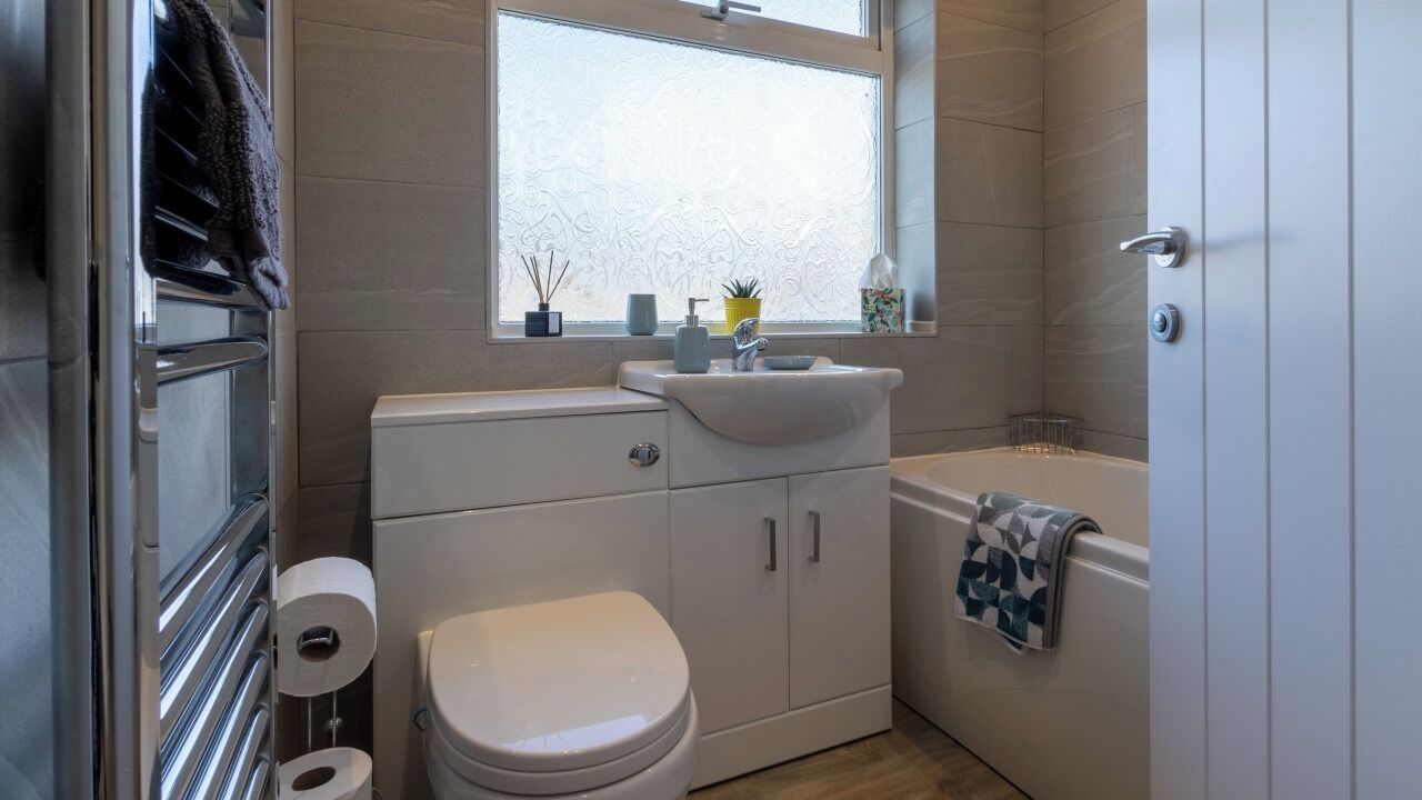 Un baño pequeño con inodoro, lavamanos y bañera.