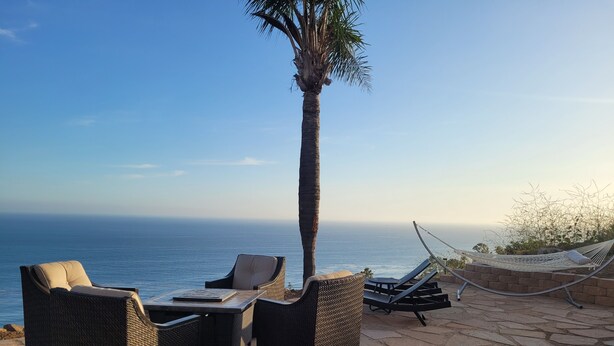 A patio with wicker furniture and a hammock overlooking the ocean. - Ocean Sunsets 1 bd Guesthouse
Forever ocean views, short stroll to the sand  (Malibu)