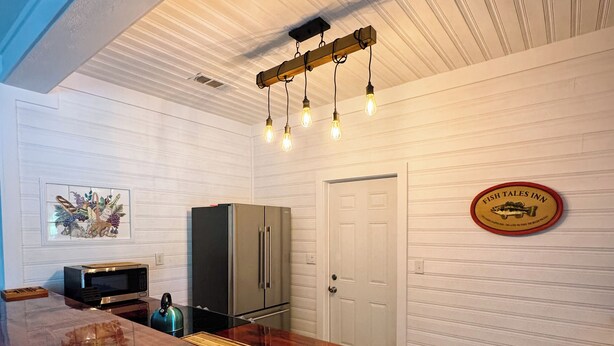 A kitchen with a wooden countertop, stainless steel appliances, and a hanging light fixture. - Charming 2-bedroom house in wonderful Bristol located on the Aplachicola River (Bristol)