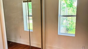 A room with hardwood flooring, a sliding glass door, and a window with a view of greenery. - Charming 2-bedroom house in wonderful Bristol located on the Aplachicola River (Bristol)