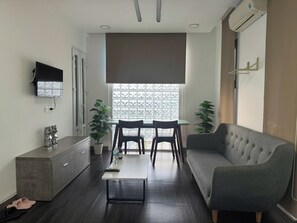 Apartamento luxo, 2 quartos, vista para a cidade | Área de estar | TV de tela plana 45 cm com canais via satélite