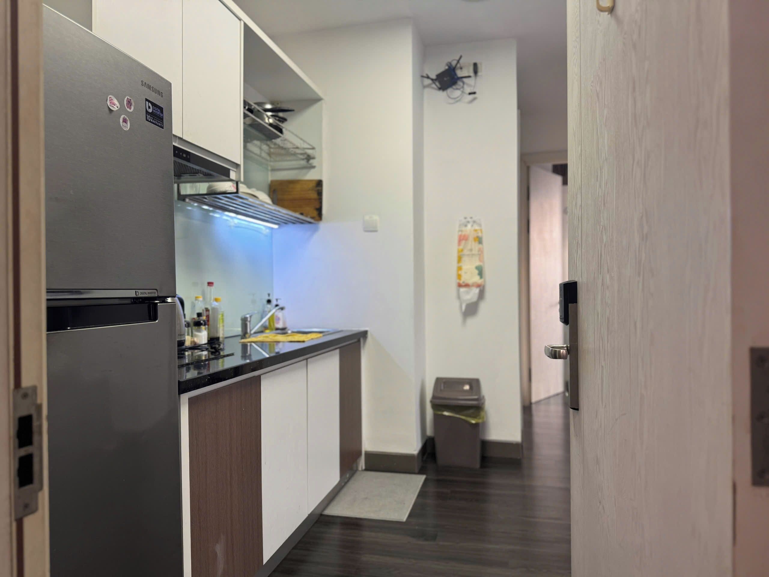 Una cocina moderna con refrigerador de acero inoxidable, armarios de madera y horno empotrado.