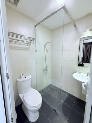 A bathroom with a toilet, a glass-enclosed shower, and a sink. - Uhouse - MELIA Thao Dien Hotel & Apartment (Ho Chi Minh City)