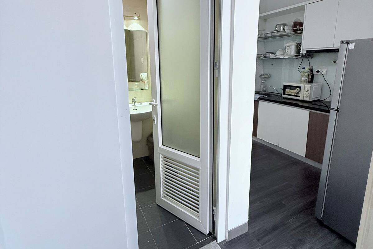 A modern kitchen with a refrigerator, microwave, and cabinets.