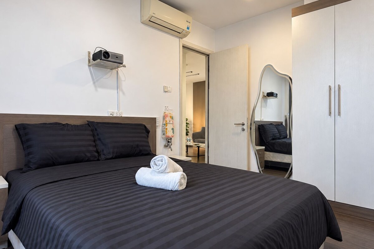 Une chambre d’hôtel équipée d’un lit, d’un miroir, d’une armoire et d’un appareil de climatisation.