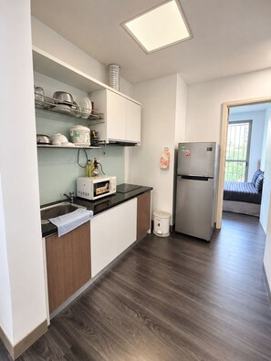 A modern kitchen with a microwave, toaster, and stainless steel refrigerator. - Uhouse - MELIA Thao Dien Hotel & Apartment (Ho Chi Minh City)