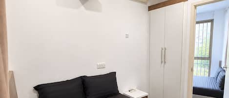 Quarto de hotel com cama, projetor, ar condicionado e guarda-roupa.