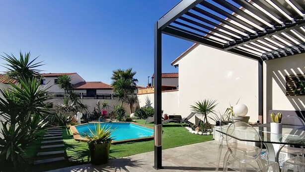 A poolside area with a clear view of a swimming pool, surrounded by potted plants and a pergola structure. - Villa cami del paradis (Corneilla-del-Vercol)