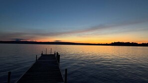 A wooden pier extending into calm water, with a sunset in the background. - La Brise O-Lac (Sherbrooke)